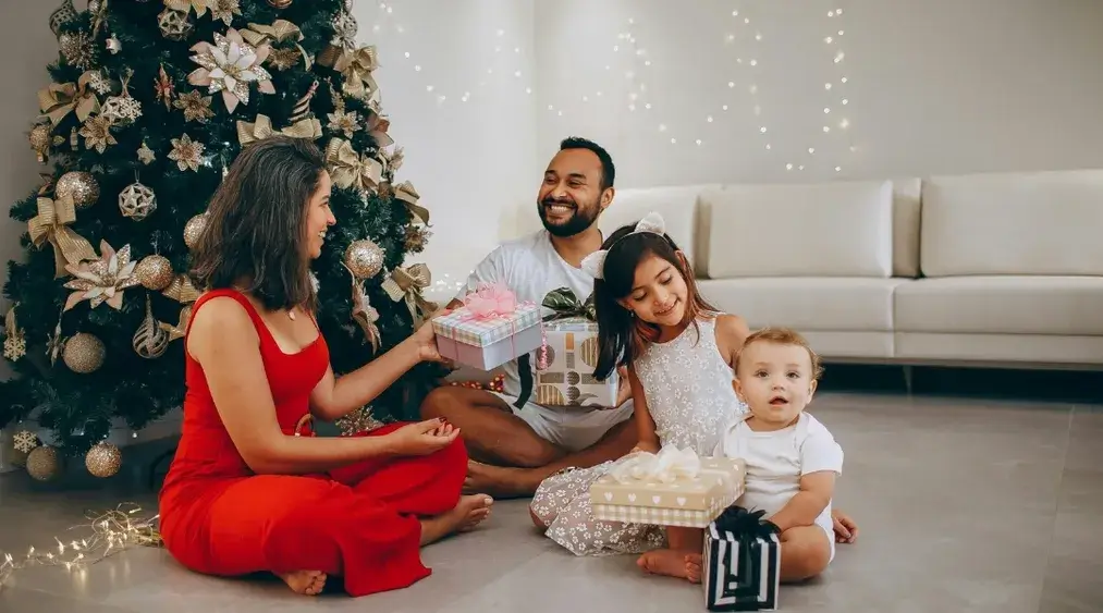Family celebrating Happy Holidays at home with Christmas tree, gifts, and warm festive atmosphere